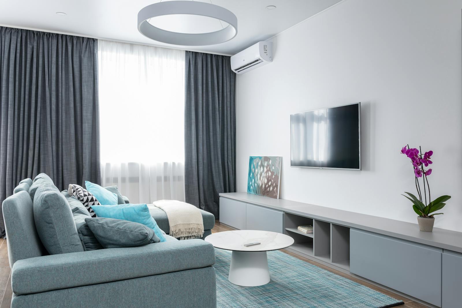 Modern wall-mounted split air-conditioning unit in a bright living room